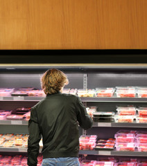 man purchasing a packet of meat at the supermarket	