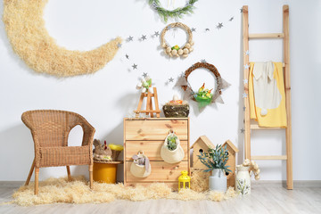 Rustic-style kids room with Easter decorations against a white wall, with wooden furniture and toys...