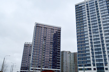 Obraz premium New modern tall blue glass multi-storey comfortable urban monolithic frame houses buildings skyscrapers new buildings in the big city of the megalopolis