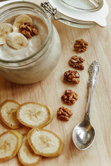 Natural yogurt with banana slices and walnuts. Healthy breakfast made from natural products.