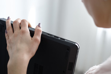 caucasian girl looking to laptop interfaces. close up usb ports and hdmi video port.