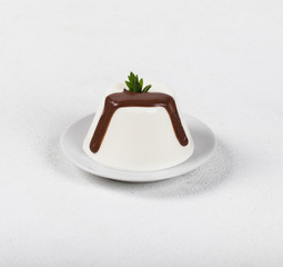 Italian dessert Panna cotta with chocolate on a light background
