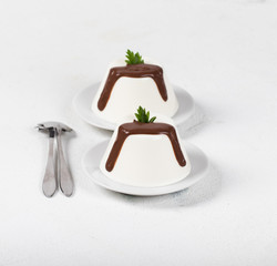 Italian dessert Panna cotta with chocolate on a light background