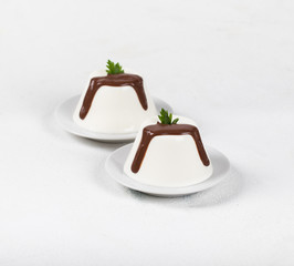 Italian dessert Panna cotta with chocolate on a light background