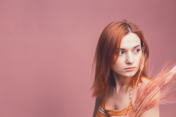 Red-haired girl on a pink background shows different emotions