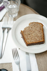 Morning breakfast with a glass of water and a heap of bread toast on a white plate lying on a white plate and next to a fork.
