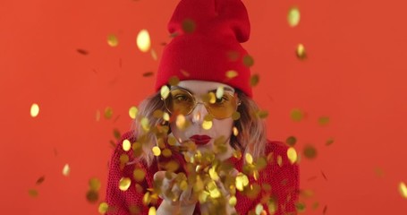 Portrait happy smile woman in star sunglasses inflates bubble from chewing gum balloon and bursts it in on blue background. Slow motion. Emotions of people. Lifestyle. Party. Monotone.  - Powered by Adobe