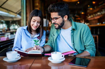 Couple on coffee break. Young students learning in the cafe for seminar. Education, relationships, love concept