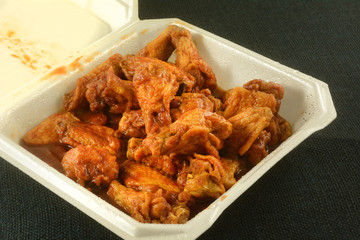 Hot barbeque chicken wings in take out container with water droplet condensation on container