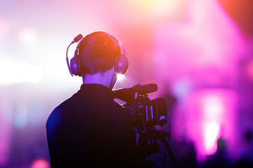Cameraman at event. Purple background.