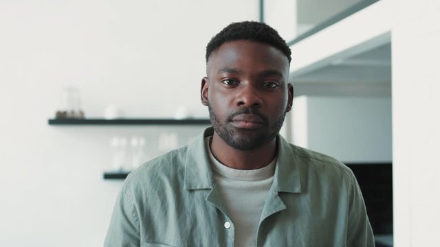 Portrait of serious african american man looking to the camera in modern room at home optimistic decisive healthy handsom close up