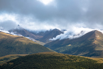 Overcast in mountains. Beautiful mountain rocks in clouds. Landscape of the North Caucasus