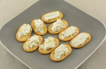 Gournay garlic and herb soft cheese and crackers snack on small plate