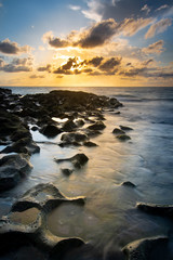 Obraz premium Surf flowing over rocks at sunrise on Singer Island