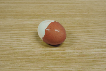 Boiled chicken egg isolated on wood table background.