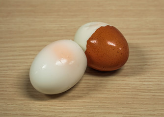 Boiled chicken egg isolated on wood table background.