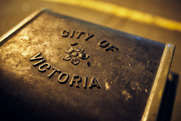 Iron City of Victoria Emblem on Top of City Garbage Bin at Night