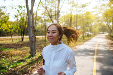 A young asian woman jogging in city park in the morning