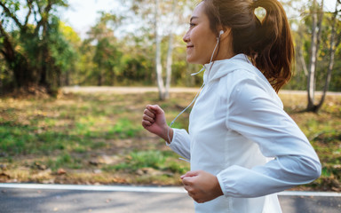 A young asian woman jogging in city park in the morning