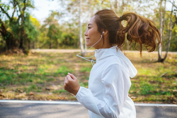 A young asian woman jogging in city park in the morning