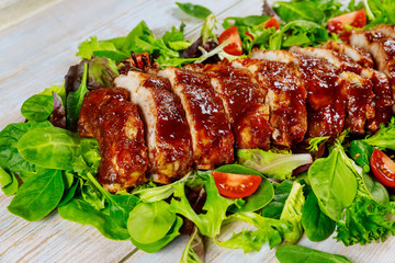 Delicious BBQ pork ribs with green salad and tangy BBQ sauce.