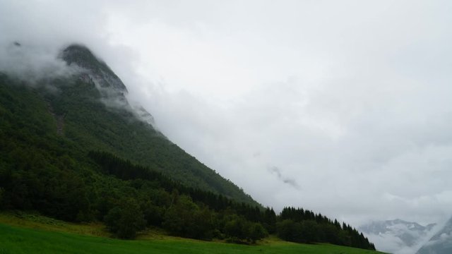Clouds rushing along the mountainside - timelaps from Urke in Norway with cows in a field