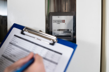 Male Technician Writing Reading Of Meter