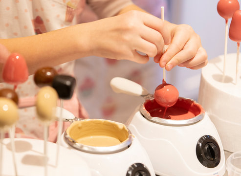 Moderne Cakepops mit Schokolade / Cany Melts &uuml;berzug dekoriert mit Zuckerstreusel Kuchen am Stiel Fondant Dekoration