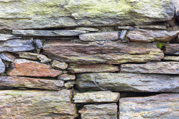 old stone wall with green moss and stones