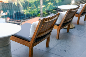 pillow cushion on wooden chair in hotel resort for relaxing at poolside
