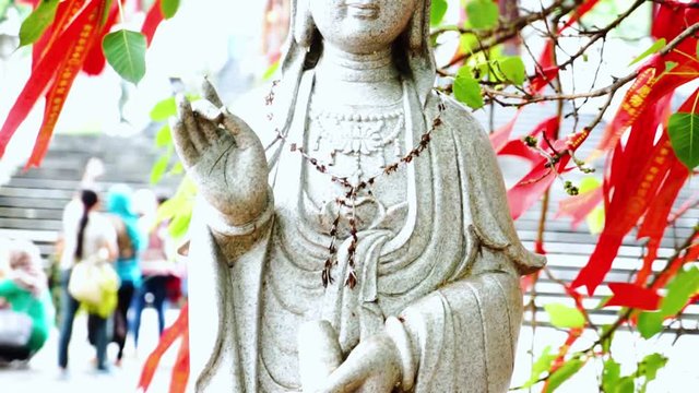 Video footage of Kwan Im statue with red talisman