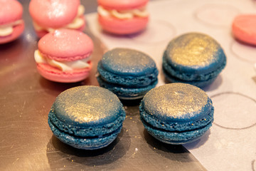 Bunte Macarons mit leckerer Frucht und Knusper Karamell Creme gefüllt Dekoriert mit essbaren Blüten und Glitzerpuder