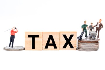 Tax reform concept with wooden tiles, worker  and CEO playing golf miniature. In current economy,...