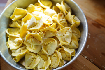 Pork wonton in bowl on wood table on aluminium tray.