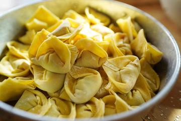 Pork wonton in bowl on wood table on aluminium tray.
