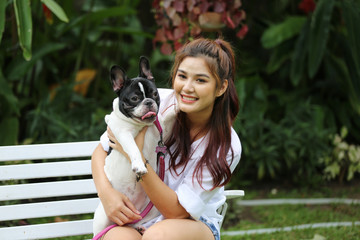 young women play with her dog in garden