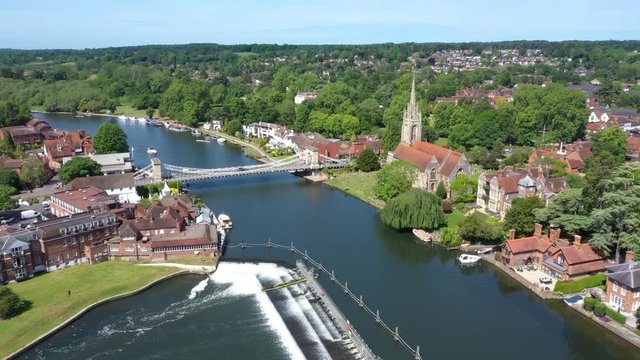 Low level 4K aerial footage flying over the River Thames towards the church in Marlow, Buckinghamshire