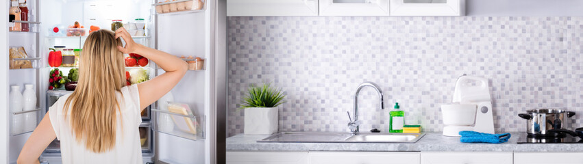 Rear View Of Woman Looking In Fridge