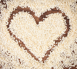 Heart of sesame seeds on board, healthy nutrition concept and sumbol of love