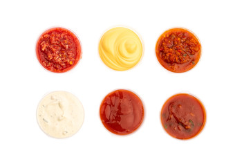spicy meat seasonings ketchup, adjika, sauce in transparent plastic containers isolated
