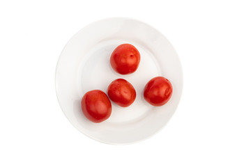 Naklejka na ściany i meble four pickled red tomatoes on a white plate isolated