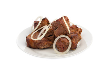 Skewers in large pieces of pork meat with onions on a white plate isolated