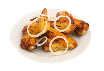 grilled chicken wings on a white plate with onion isolated