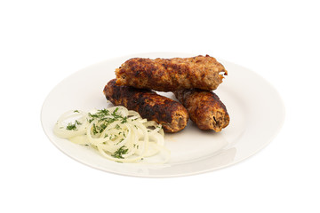 baked on a skewer grill meat long cutlet on a white plate with onions and herbs isolated