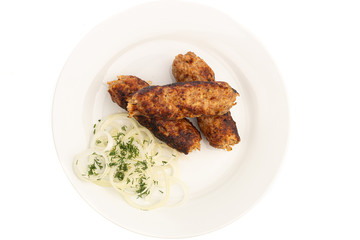 baked on a skewer grill meat long cutlet on a white plate with onions and herbs isolated