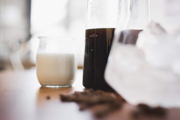cold brew carafe with glass of milk and glass of ice – side
