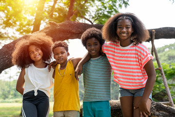 Group of children standing together, kids diverse hugging in the park.