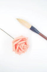 Pink roses and an inkless brush on a white background