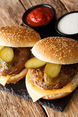 Hot fresh Oklahoma fried onion burgers served with ketchup and mayonnaise close-up on a slate board. vertical