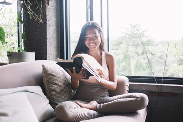 Cheerful lady with book on sofa